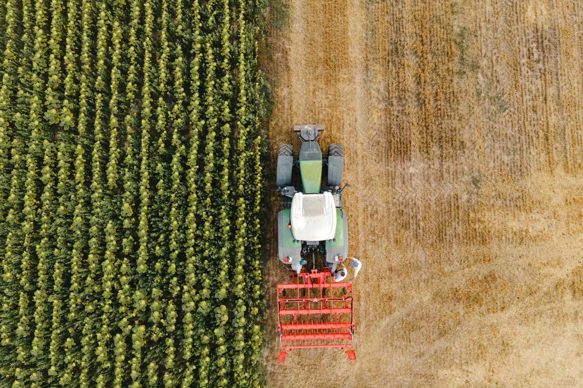 Traktor s vybavením pracující na poli
